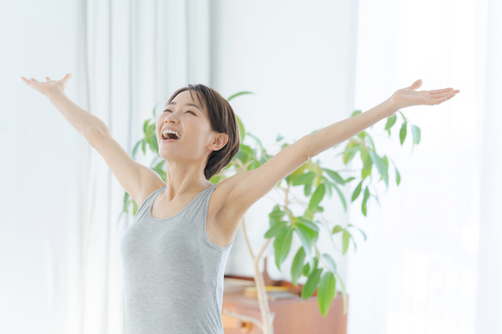 朝に伸びをする女性のイメージ
